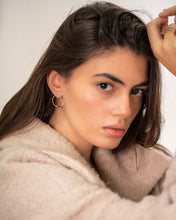 Load image into Gallery viewer, Woman with styled hair wearing a beige coat against a neutral background