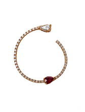 Load image into Gallery viewer, A gold-colored bracelet with a red charm and white accents, designed to be worn on the fingers.