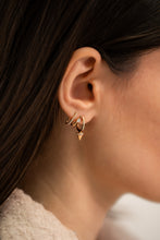 Load image into Gallery viewer, Close-up of an ear wearing gold hoop earrings with a blurred background