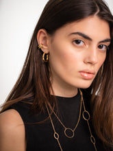 Load image into Gallery viewer, Close-up of a woman wearing gold hoop earrings and a gold necklace against a white background