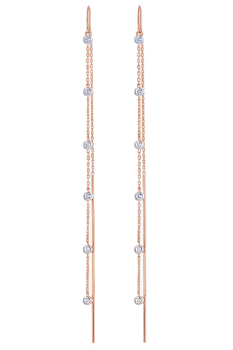 Pair of rose gold earrings with clear gemstones on a white background
