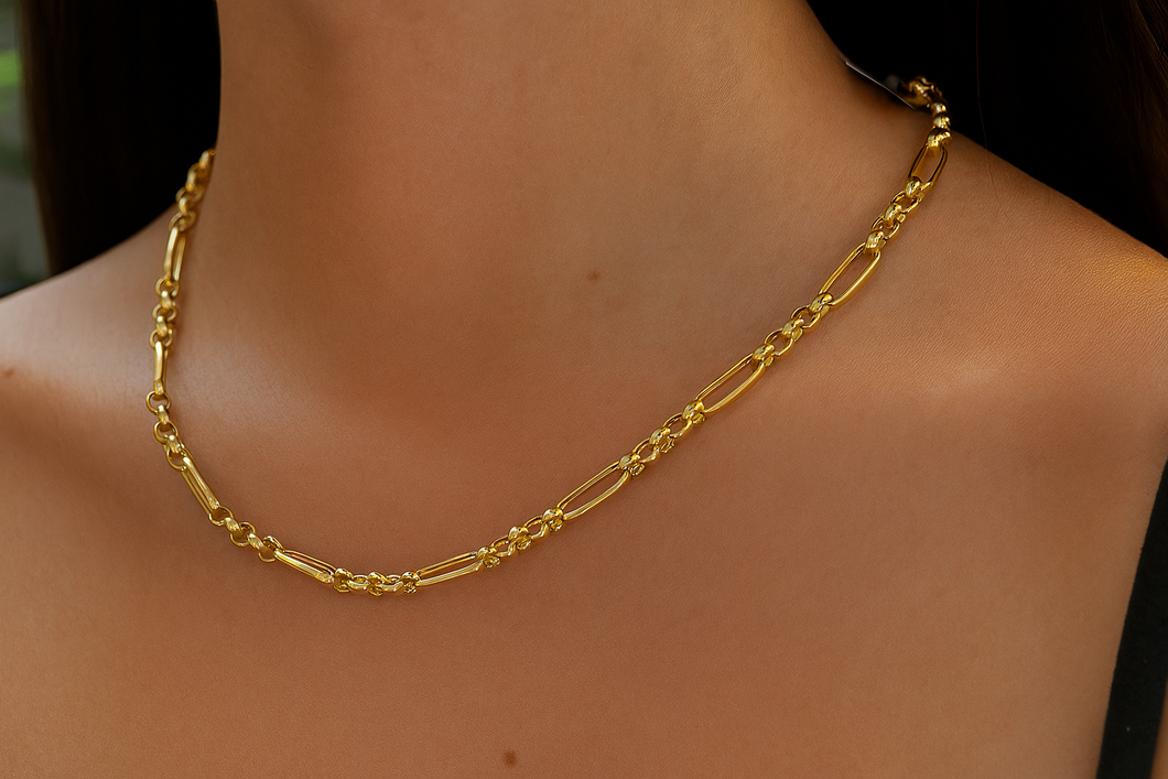 Gold chain necklace on a person's neck with a blurred background