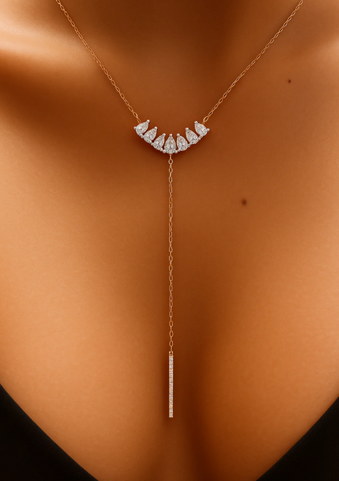 Gold necklace with diamond accents on a person's neck