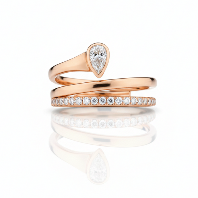 Rose gold ring with a teardrop-shaped gemstone on a white background
