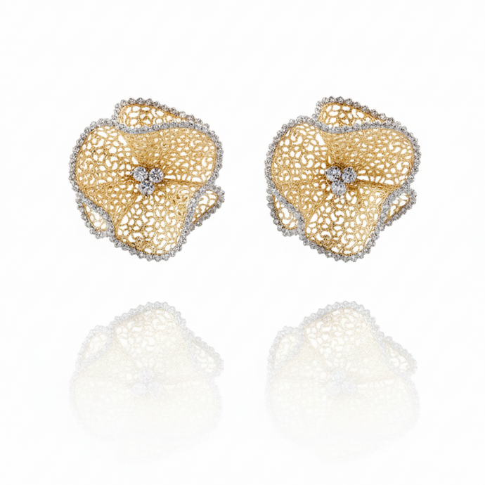 Gold floral earrings with diamond centers on a white background
