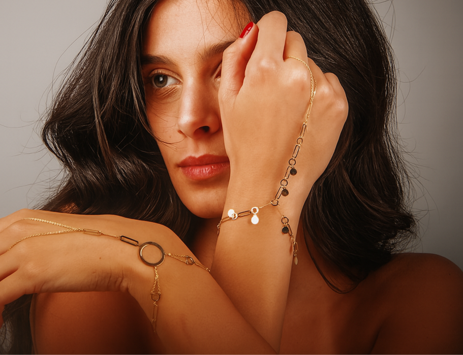 Woman wearing gold jewelry with a neutral background