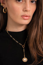 Load image into Gallery viewer, A person wearing a black tank top adorned with a gold-colored chain necklace featuring a circular charm pendant.
