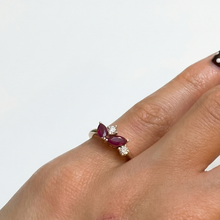 Load image into Gallery viewer, Hand wearing a ring with a purple gemstone on a light gray background
