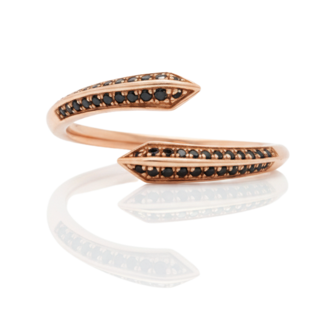 Rose gold ring with black gemstones on a white background