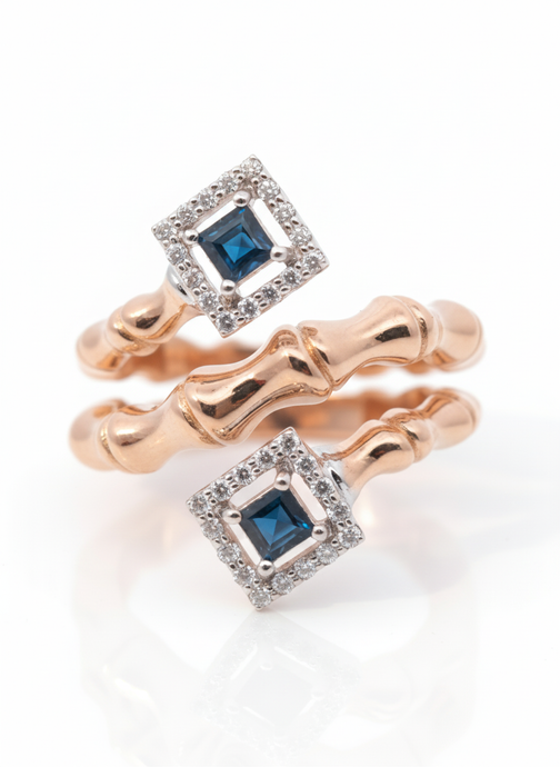 Two rings with blue gemstones and rose gold band on a white background