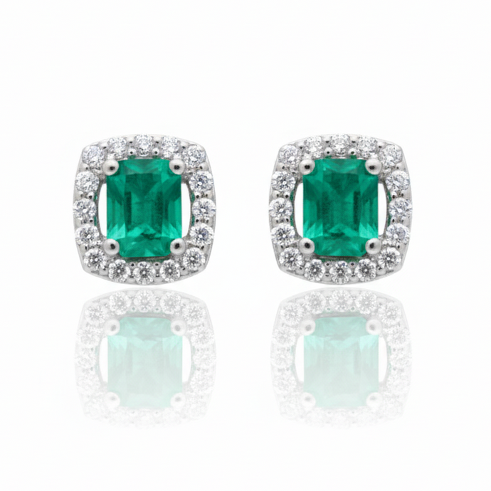 Pair of emerald green gemstone earrings with silver borders on a white background