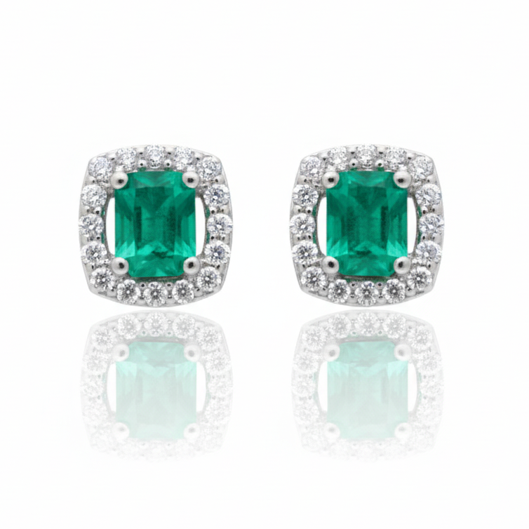 Pair of emerald green gemstone earrings with silver borders on a white background
